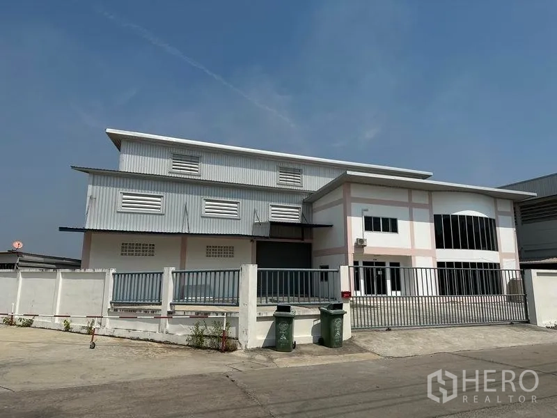 คลังสินค้า ให้เช่าในSamut Prakan - มุมมองด้านหน้าคอมเพล็กซ์โกดัง มีประตูรั้วและพื้นที่จอดรถ