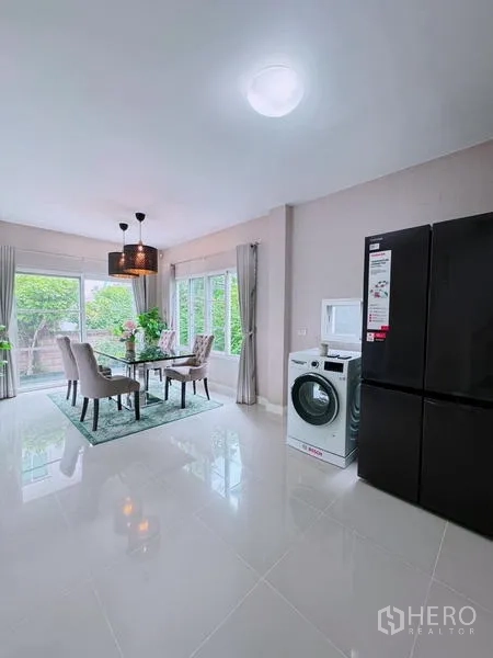 Detached House for rent in Prawet, Bangkok - Dining zone with fridge and washing machine in a bright corner.