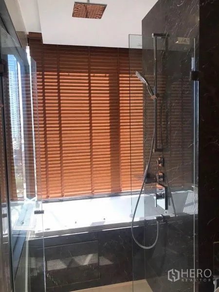 คอนโด ให้เช่าในBang Rak, Bangkok - ห้องน้ำหรูพร้อมตู้กระจก ฝักบัวเรนชาวเวอร์ อ่างอาบน้ำ และมู่ลี่ไม้โทนอุ่น