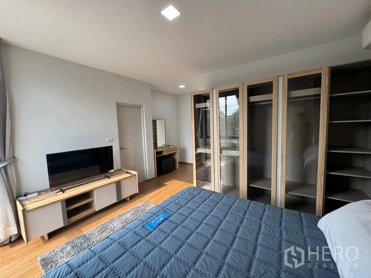 Townhouse for rent in Bang Phli, Samut Prakan - Bright bedroom with TV console, large glass-door wardrobes, and a double bed.