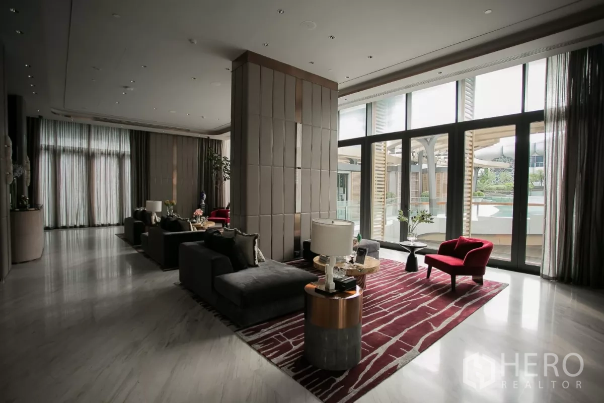 公寓 出租在Watthana, Bangkok - 会所铺红色地毯，转角沙发与落地窗临池。