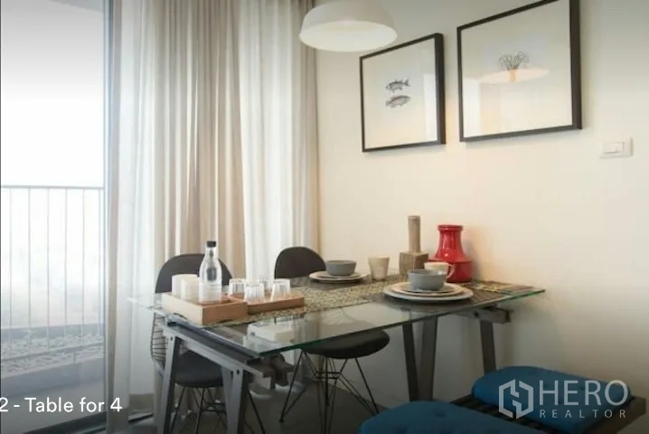 คอนโด ให้เช่าในPhaya Thai, Bangkok - มุมรับประทานอาหารโต๊ะกระจกสำหรับ 4 ที่นั่ง ข้างประตูระเบียงและผ้าม่านโปร่ง