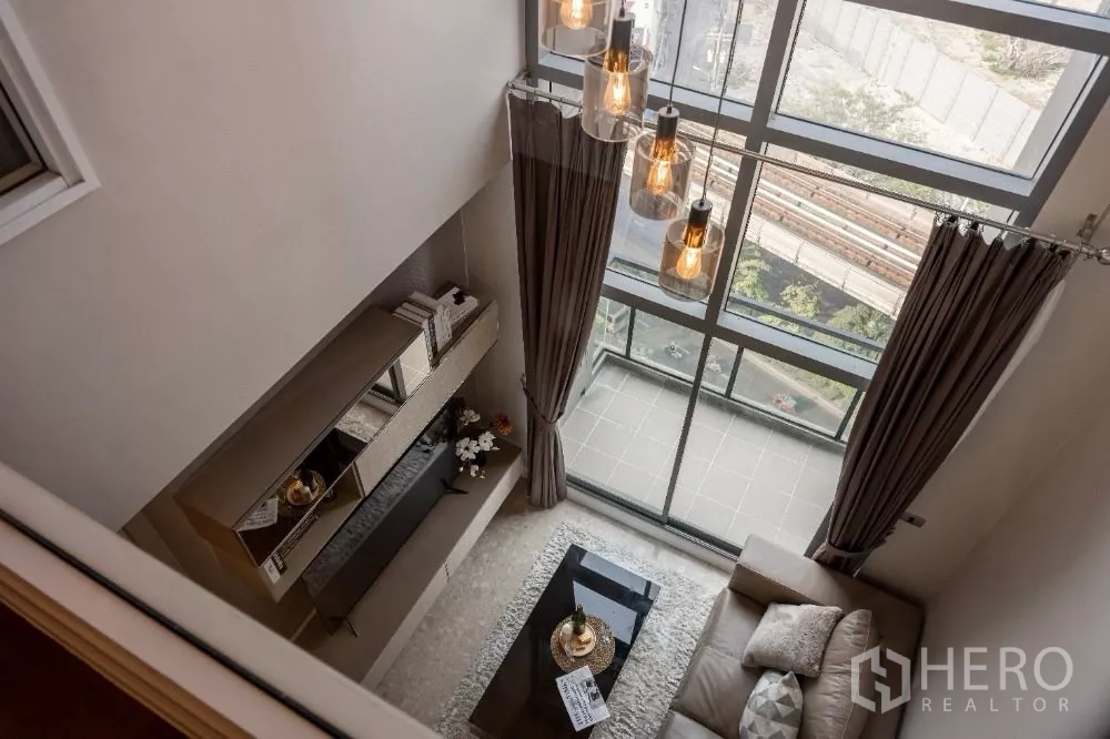 คอนโด ให้เช่าหรือขายในKhlong Toei, Bangkok - ห้องนั่งเล่นเพดานสูงสองชั้น พร้อมกระจกเต็มผนังและระเบียง