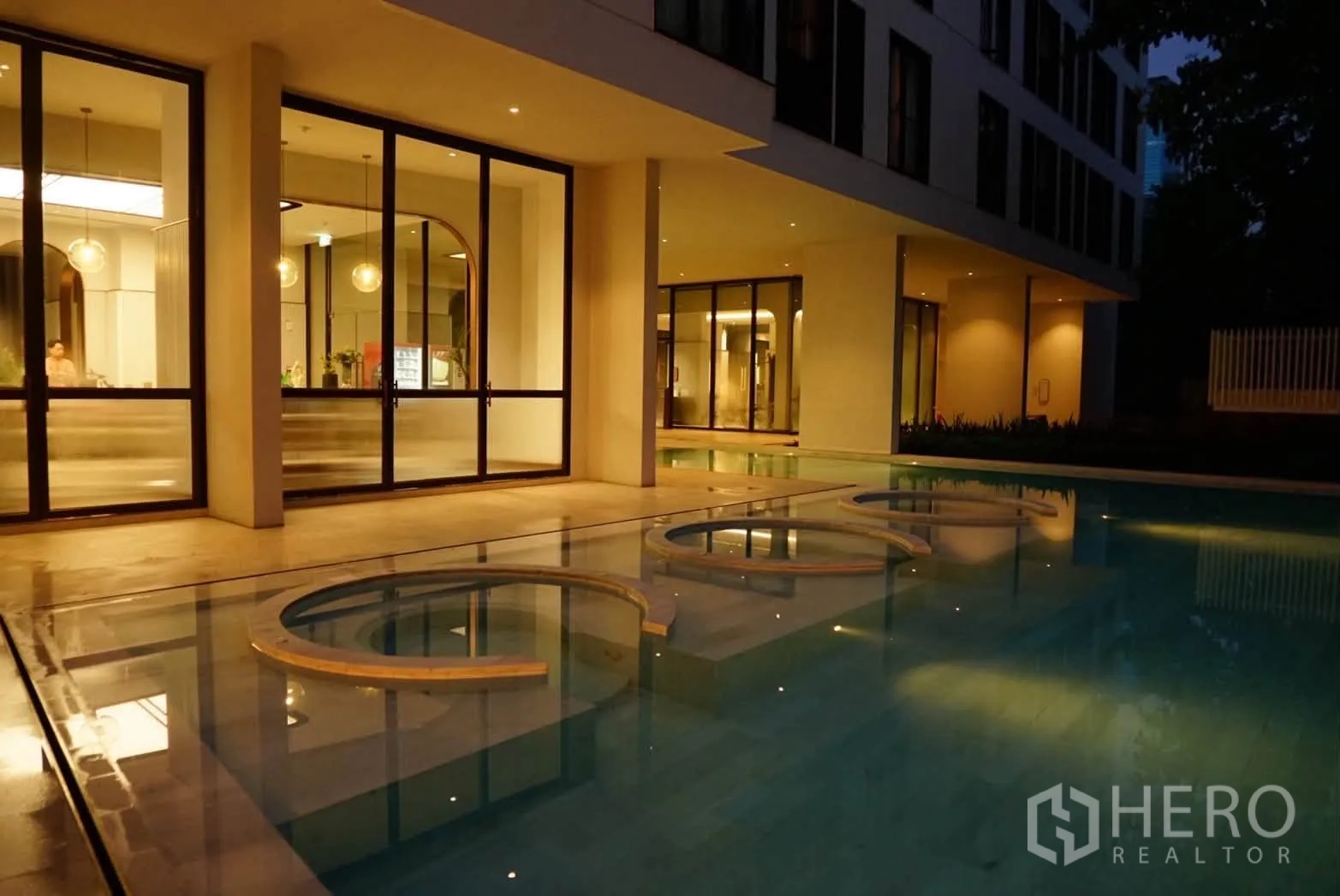 คอนโด for rent in Watthana, Bangkok - บรรยากาศยามค่ำของสระว่ายน้ำติดล็อบบี้กระจกพร้อมแสงไฟสวยงาม