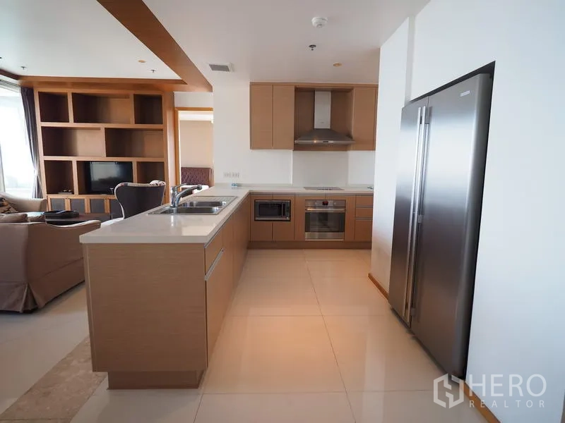 Condominium for rent in Sathon, Bangkok - Modern open kitchen with island sink, built-in oven, range hood and double-door refrigerator.