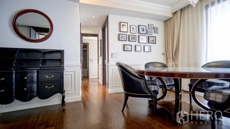 คอนโด ให้เช่าหรือขายในKhlong Toei, Bangkok - มุมรับประทานอาหารโต๊ะกลม เก้าอี้สีดำ ผนังบัว กรอบรูป และพื้นไม้