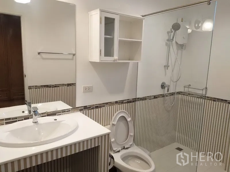 联排别墅 出租在Mueang Samut Prakan, Samut Prakan - 浴室带玻璃淋浴间、台上盆与条纹瓷砖。