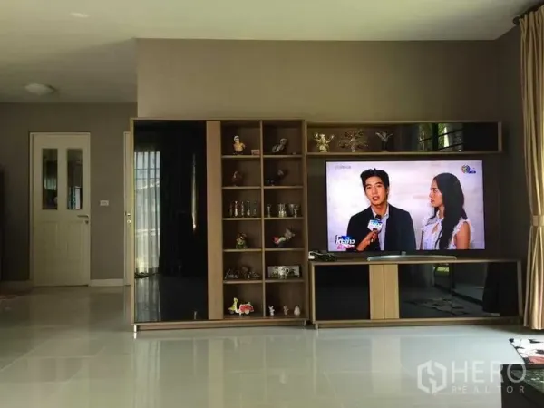 Detached House for sale in Khlong Sam Wa, Bangkok - Bright living room with built-in TV wall unit and glossy tiled floor.