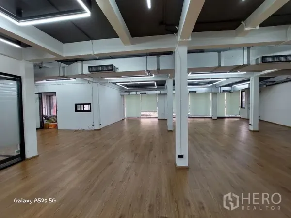 สำนักงานที่บ้าน ให้เช่าในKhlong Toei, Bangkok - พื้นที่เปิดโล่งกว้าง มีเสาหลายต้น ม่านม้วน เครื่องปรับอากาศเดินท่อ และพื้นลายไม้