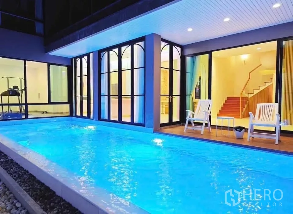 独立式住宅 出租在Phaya Thai, Bangkok - 私人泳池与落地玻璃客厅相连，池畔休闲椅。