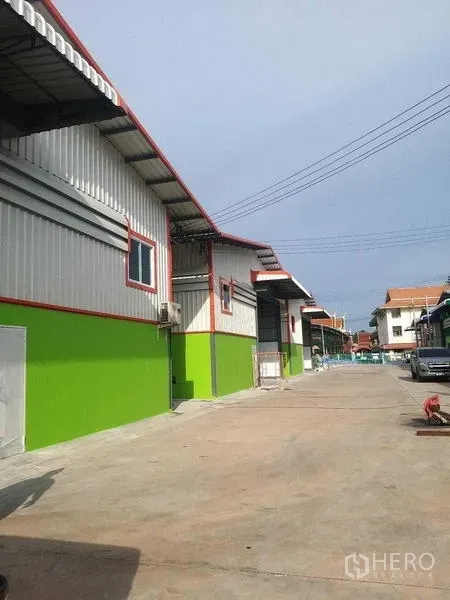 Warehouse for rent in Bang Khun Thian, Bangkok - Row of warehouses with a wide internal road for truck access in the compound.