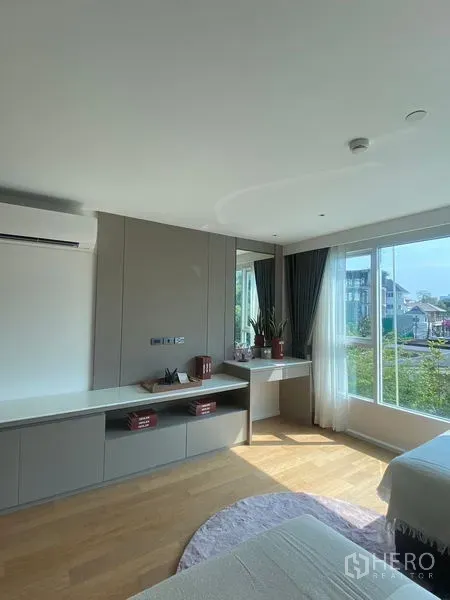 Condominium for rent in Watthana, Bangkok - Bright bedroom corner with built-in desk and wide windows overlooking the neighborhood.