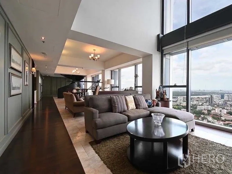 Condominium for rent - Daytime living area with grey sofa, skyline views and feature lighting.