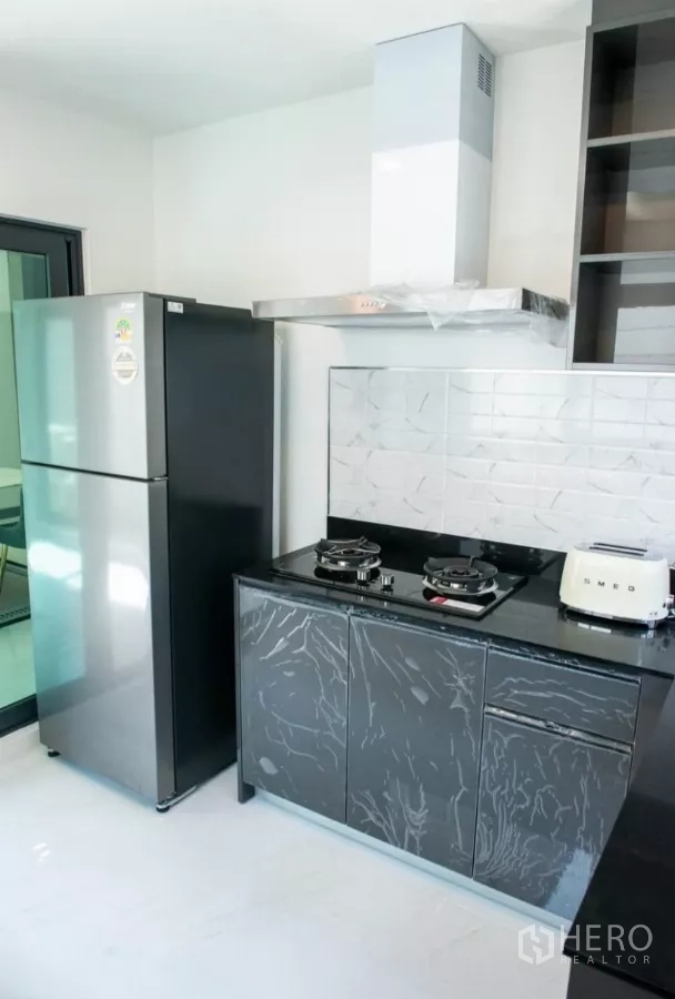 Detached House for rent in Bang Phli, Samut Prakan - Modern kitchen with gas hob, chimney hood, tiled backsplash and a large refrigerator.