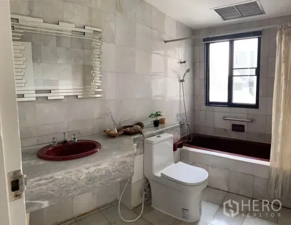Townhouse for rent in Watthana, Bangkok - Bathroom with soaking tub, marble vanity and red basin beside a bright window.