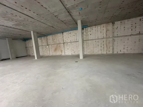 零售空间 出租在Bang Na, Bangkok - 未装修商铺内部，裸露砌块墙、结构柱与顶面管线
