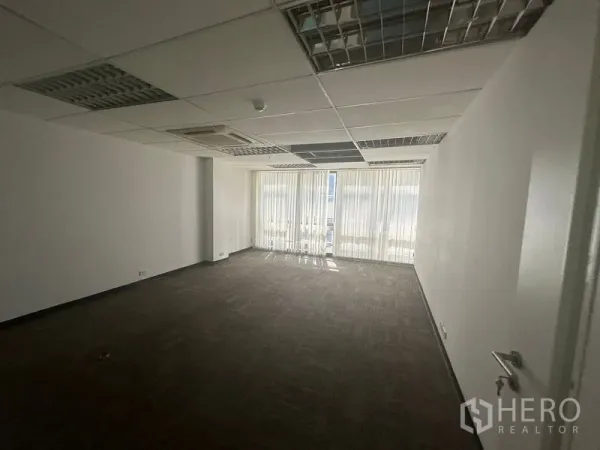 办公空间 出租在Khlong Toei, Bangkok - 长方形办公室，地毯砖、吊顶嵌入式空调与落地窗百叶。