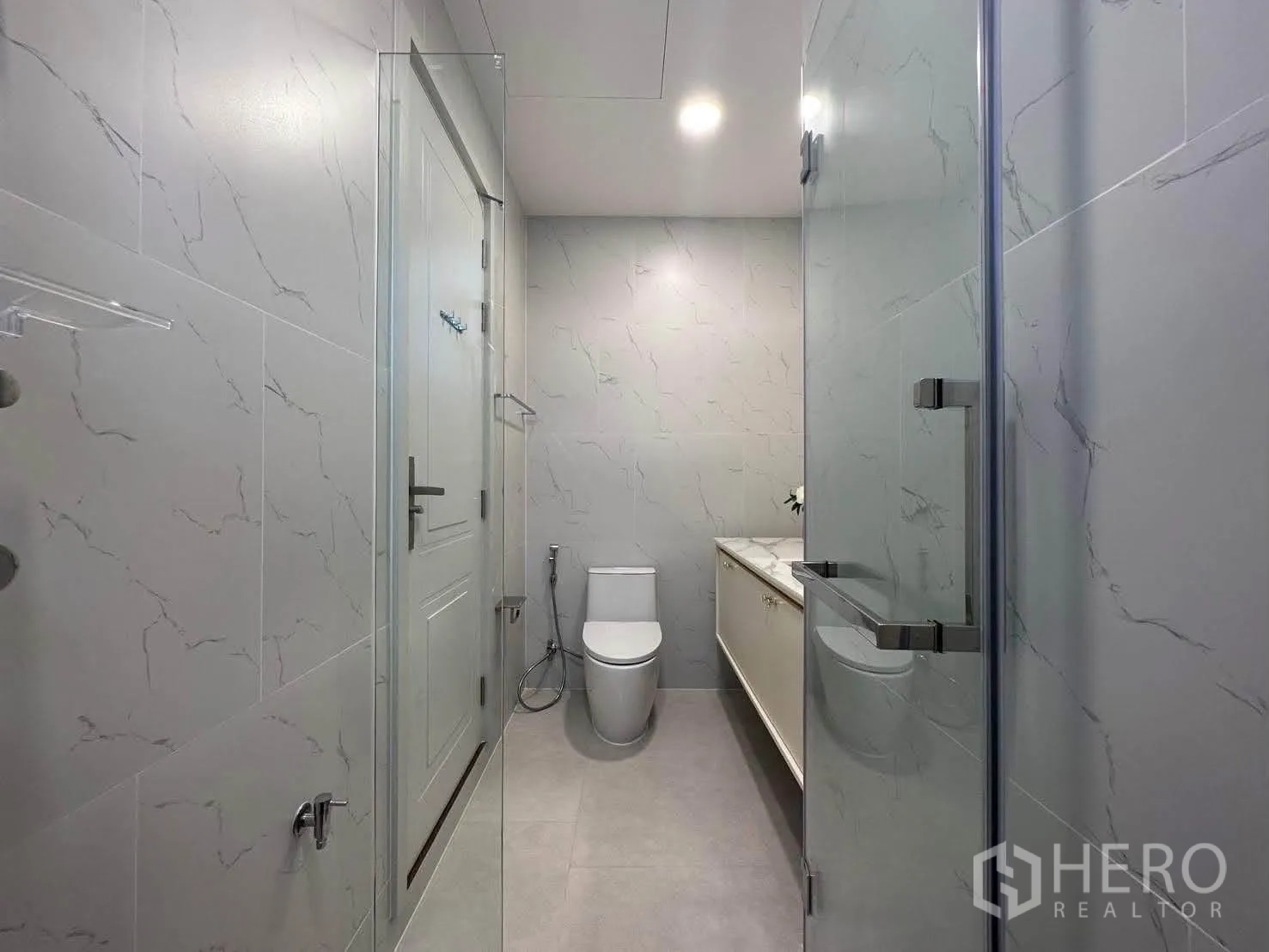 独栋房屋 for rent in Saphan Sung, Bangkok - 干净卫生间，玻璃淋浴间与马桶，大理石纹墙砖。