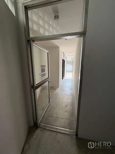 Office Space for rent in Khlong Toei, Bangkok - Interior corridor with a glass door leading into the office area.