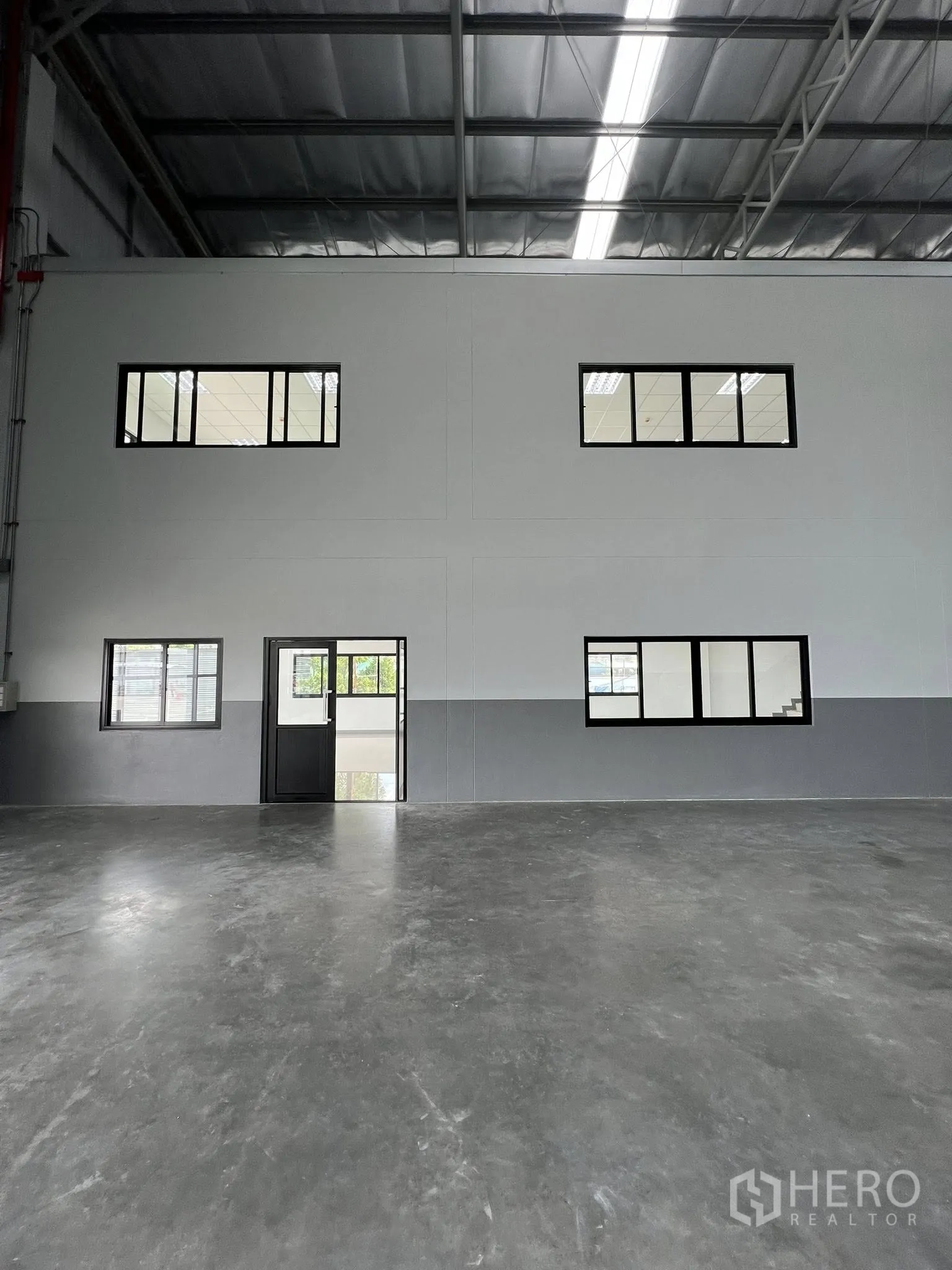 Warehouse for rent in Phra Pradaeng, Samut Prakan - Internal two-storey office block with windows and a door facing the warehouse.