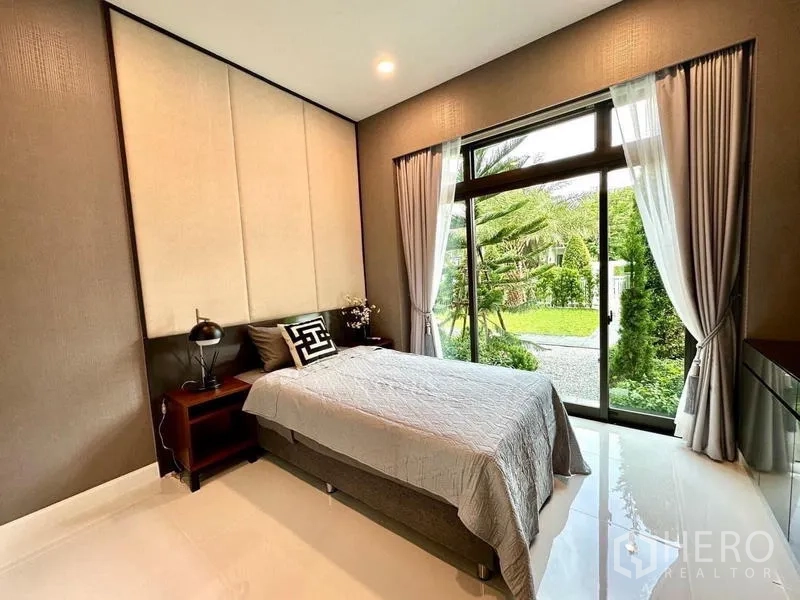 บ้าน ให้เช่าในLat Krabang, Bangkok - ห้องนอนชั้นล่าง วิวสวน หน้าต่างสูงจรดพื้น ผ้าม่านโทนอ่อน