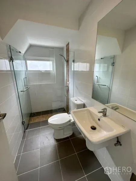 Townhouse for rent in Bang Phli, Samut Prakan - Bright bathroom with glass-enclosed shower, window, toilet and sink.