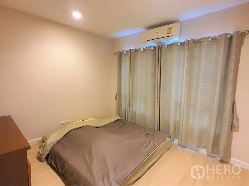 Townhouse for rent in Wang Thonglang, Bangkok - Cozy bedroom with air conditioner and blackout curtains.