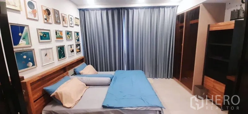 Condominium for rent or sale in Huai Khwang, Bangkok - Bedroom with blue curtains, wardrobe, and storage cabinetry.