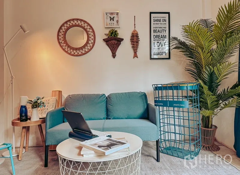 Home Office for rent in Watthana, Bangkok - Cozy lounge with a teal sofa, round coffee table, and decorative wall art.