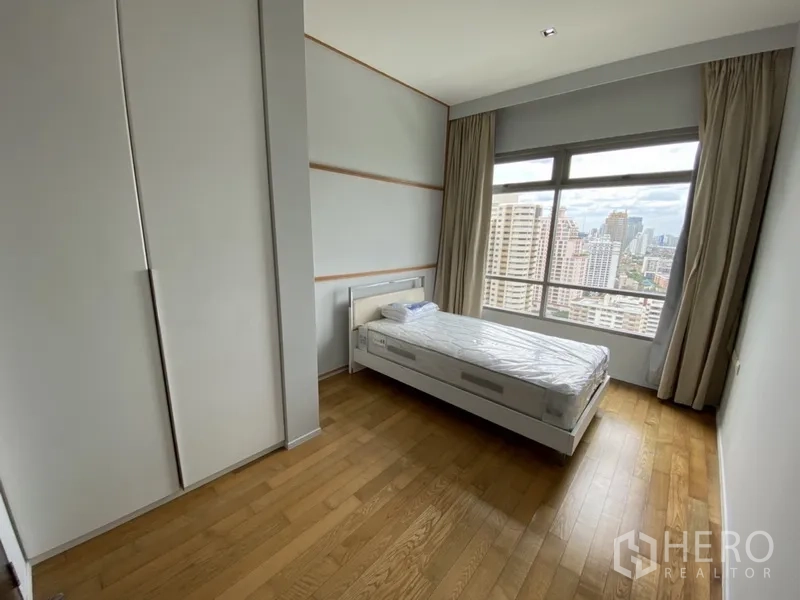 คอนโด ให้เช่าในWatthana, Bangkok - ห้องนอนสว่าง เตียงเดี่ยว ตู้เสื้อผ้าบิวท์อิน และหน้าต่างบานใหญ่เห็นวิวกรุงเทพฯ