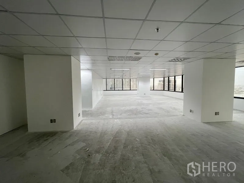 办公空间 出租在Din Daeng, Bangkok - 大面积空置办公室，吊顶灯具与环窗引入自然采光。