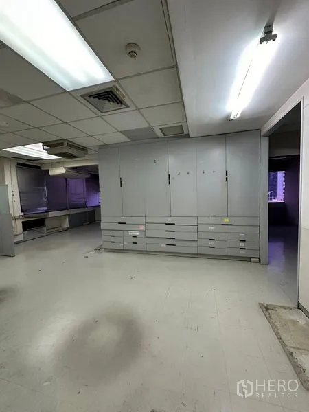 Office Space for rent in Watthana, Bangkok - Back office area with large grey storage cabinets and fluorescent lighting
