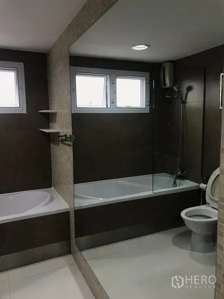 คอนโด ขายในWatthana, Bangkok - ห้องน้ำสไตล์โมเดิร์น มีอ่างอาบน้ำ กั้นกระจก โถสุขภัณฑ์ และหน้าต่างบานเล็ก