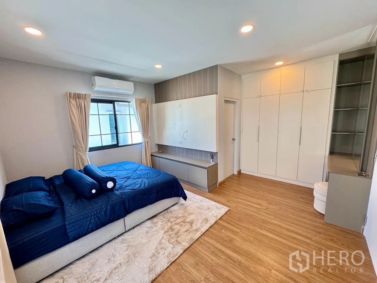 独栋房屋 for rent in Bang Phli, Samut Prakan - 宽敞卧室，蓝色床品，内置衣柜与电视墙。