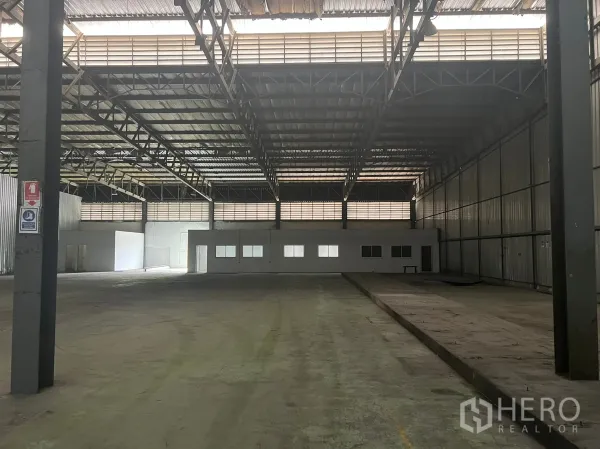 Factory for rent in Bang Pakong, Chachoengsao - Open warehouse space with metal walls, a small internal office block, high ceiling and loading bay.