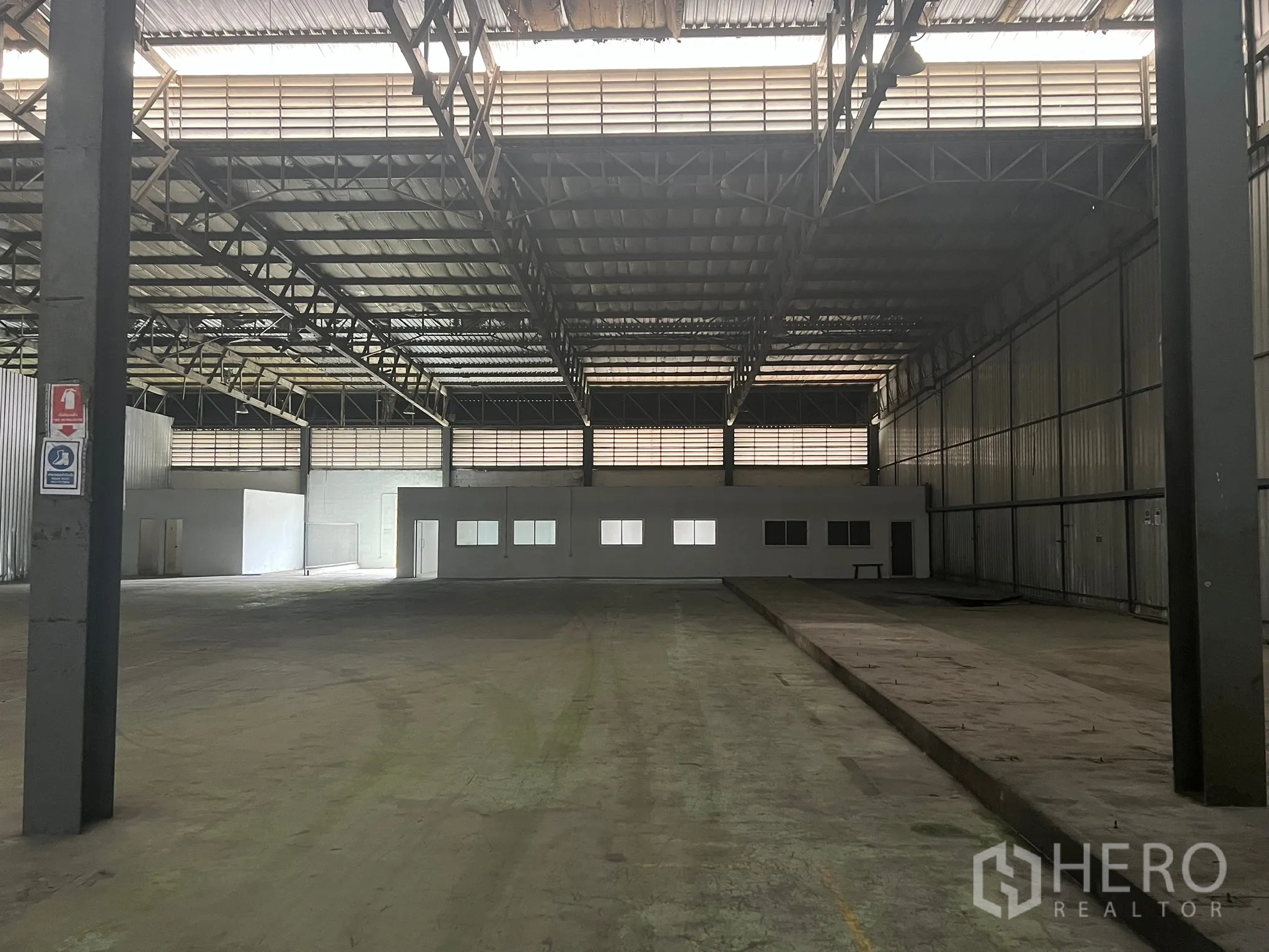 Factory for rent in Bang Pakong, Chachoengsao - Open warehouse space with metal walls, a small internal office block, high ceiling and loading bay.