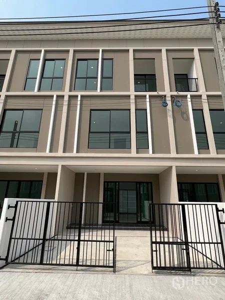Townhouse for rent in Bang Kapi, Bangkok - Three-storey modern townhouse facade with large windows and gated entry in Bang Kapi, Bangkok.