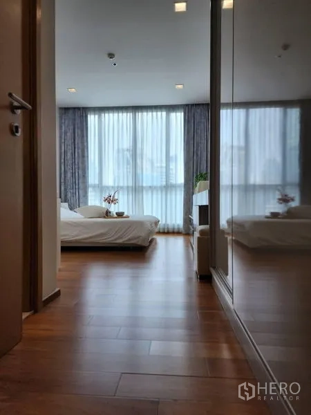 公寓 出租在Watthana, Bangkok - 走廊带镜面衣柜，通向明亮卧室。