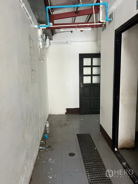店屋 出租在Wang Thonglang, Bangkok - 服务走道可见蓝色管道，瓷砖地面并通往内门。