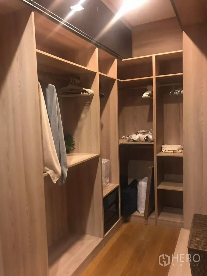 Detached House for rent in Bang Kapi, Bangkok - Walk-in closet fitted with open wood wardrobes, shelves and hanging space.