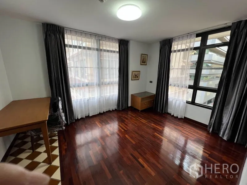 公寓 出租或出售在Watthana, Bangkok - 采光良好的转角房，落地窗与纱帘，实木地板与书桌。