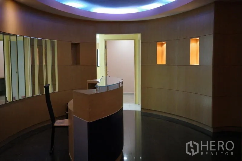 Office Space for rent in Bang Na, Bangkok - Circular lobby featuring a curved reception counter, wood panel walls and cove lighting.