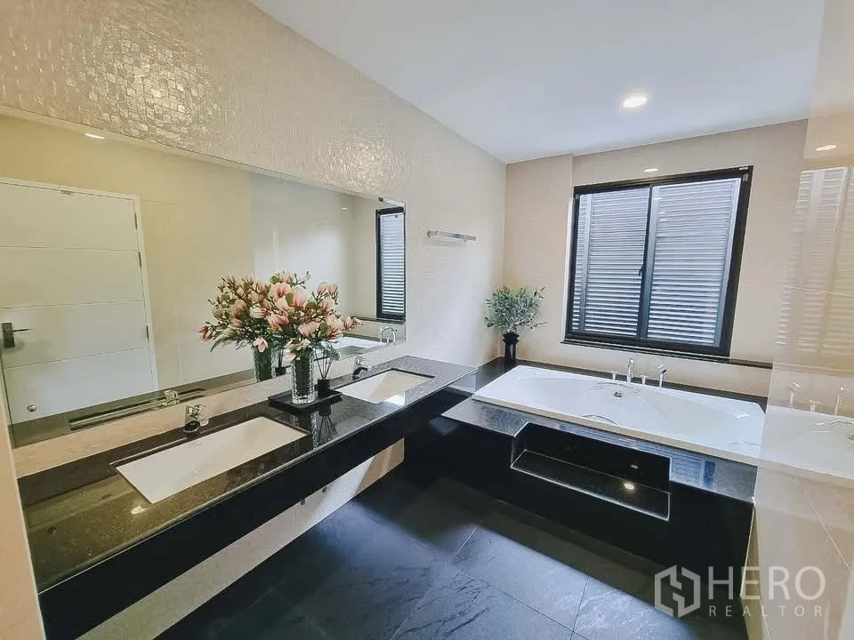 Detached House for rent or sale in Bang Phli, Samut Prakan - Elegant bathroom with double sinks, large mirror, and built-in bathtub.