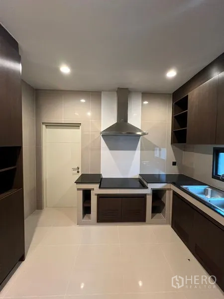 Detached House for rent in Bang Kapi, Bangkok - Separate Thai kitchen with hood, built-in cabinets and tiled walls.