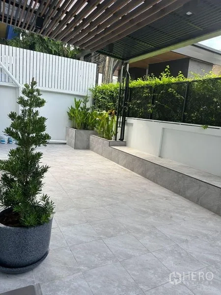 Detached House for rent in Suan Luang, Bangkok - Tiled outdoor patio with planters, privacy fence and shaded roof slats.