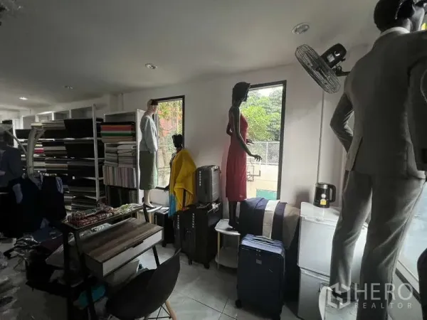 零售空间 出租在Khlong Toei, Bangkok - 靠窗展示区，可见绿植景观，配有货架与行李展示。