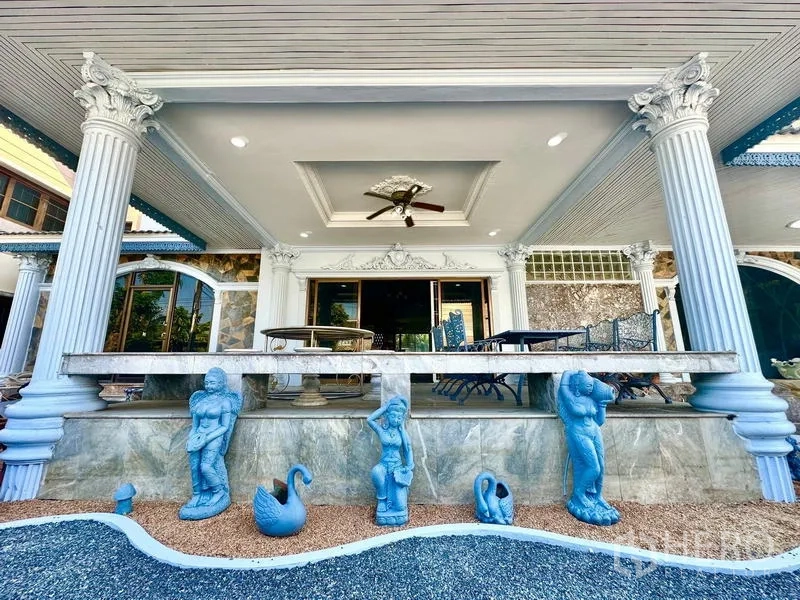 บ้าน ให้เช่าในTaling Chan, Bangkok - ชานบ้านยกพื้น เสาแบบคลาสสิก พัดลมเพดาน และที่นั่งกลางสวนจัดแต่ง.