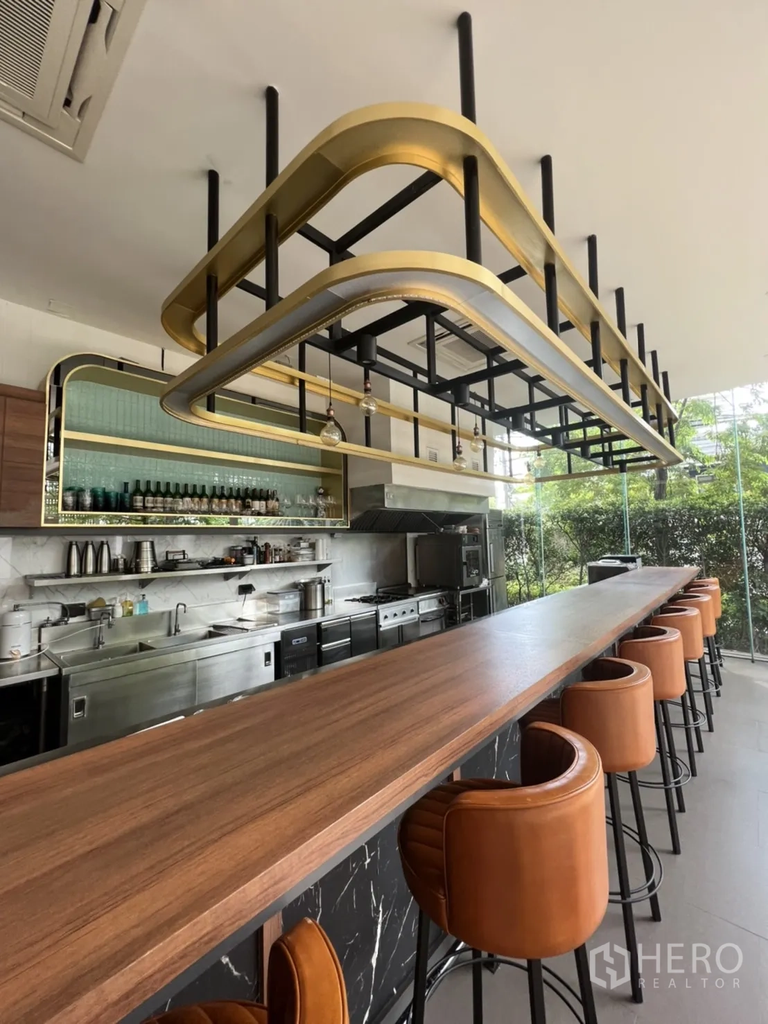 พื้นที่ขายปลีก ให้เช่าในWatthana, Bangkok - มุมมองเคาน์เตอร์บาร์สูงและโครงไฟสีทอง‑ดำ พร้อมที่นั่งและฐานหินอ่อน