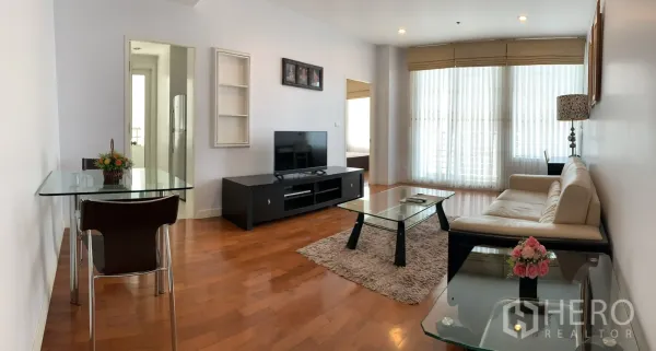 公寓 出租在Khlong Toei, Bangkok - 开放式起居餐区，玻璃桌、电视柜与纱帘，让自然光充满空间。