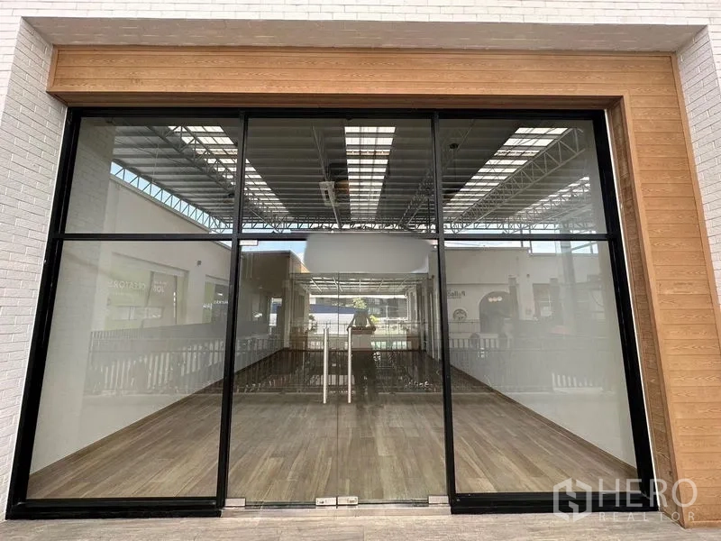 零售空间 出租 - 面向通道的玻璃店面，双扇门与木质边框。